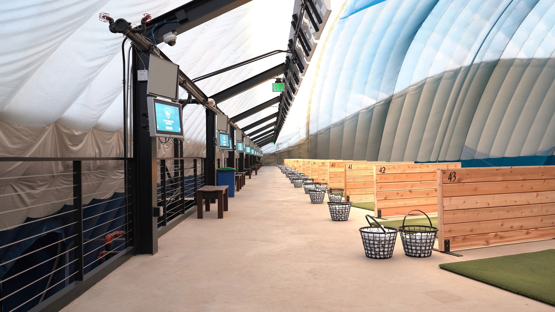 Hitting bays with Toptracer screens at the Braemar Golf Dome